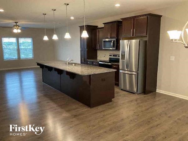 an empty kitchen with a stainless steel refrigerator