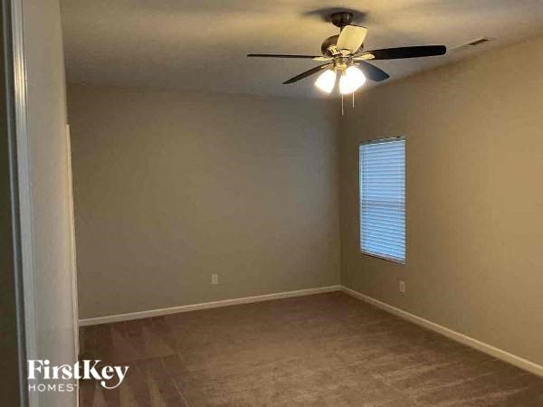an empty room with a ceiling fan and a window