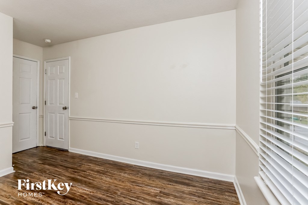 the living room of a home with a wood floor and white walls