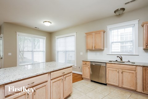 A kitchen with wooden cabinets and a stainless steel dishwasher.