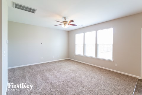 a living room with a ceiling fan and a large window