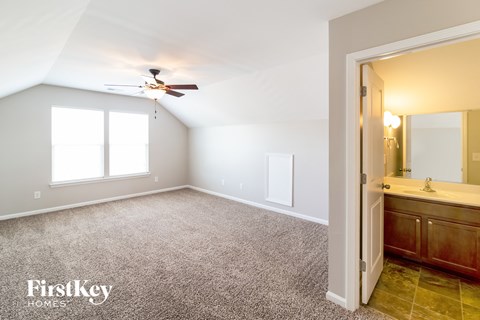 a master bedroom with a bathroom and a ceiling fan