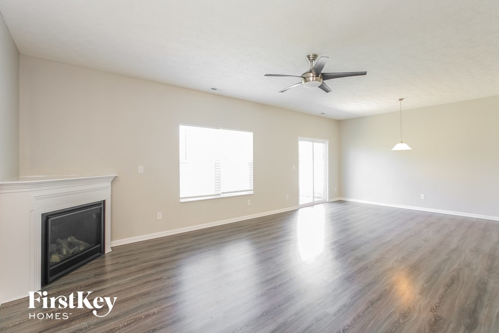 a living room with a fireplace and a ceiling fan