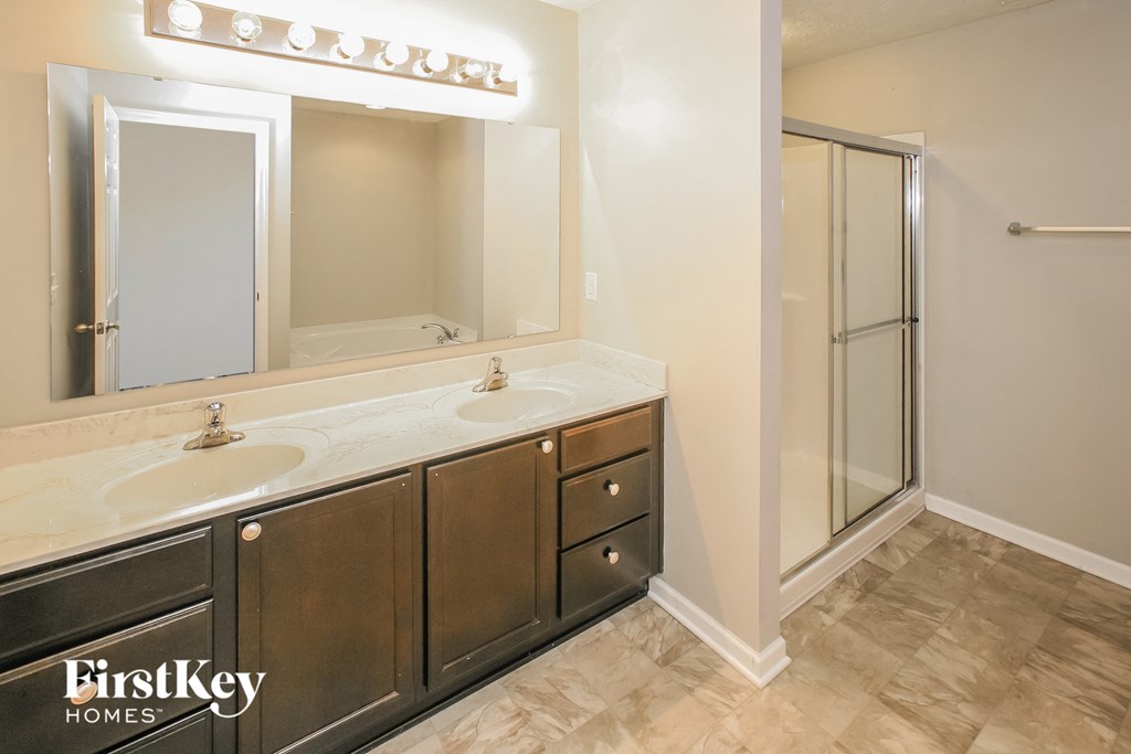 a bathroom with two sinks and a shower