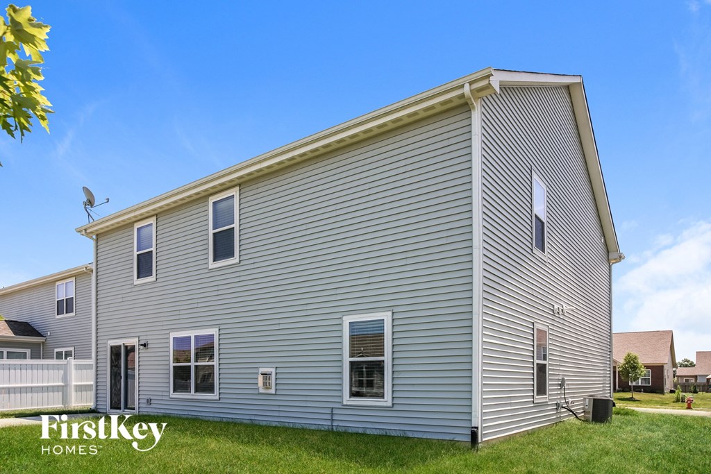 the outside of a gray house with blue siding
