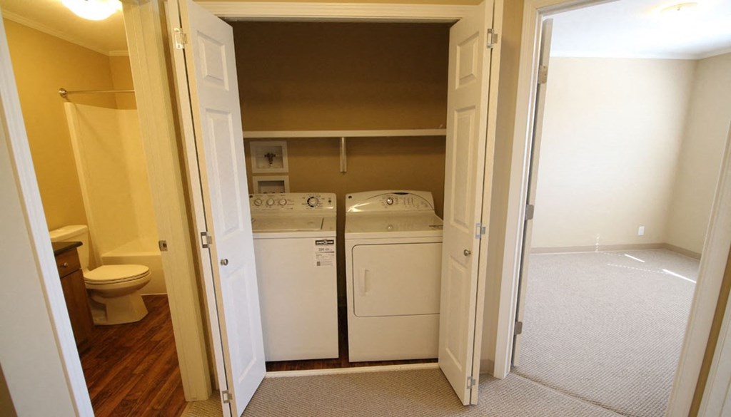 a room with a washer and dryer and a toilet