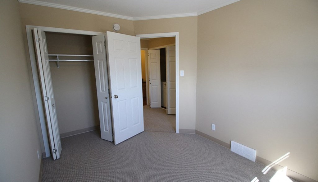 a bedroom with a closet and a door to a hallway