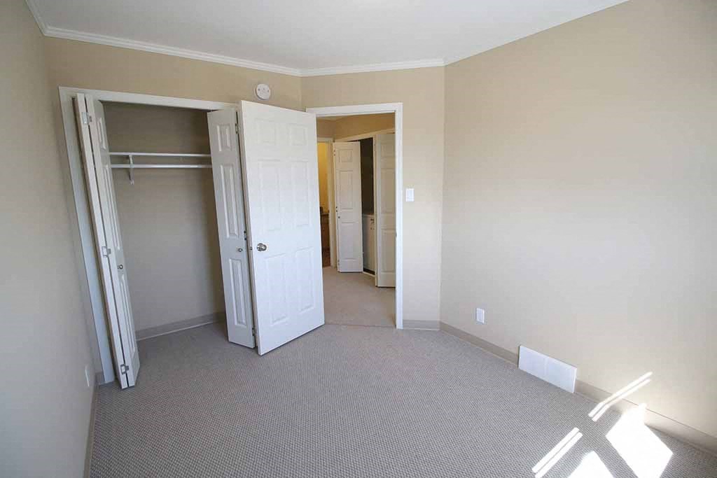 a bedroom with a closet and a door to a bathroom