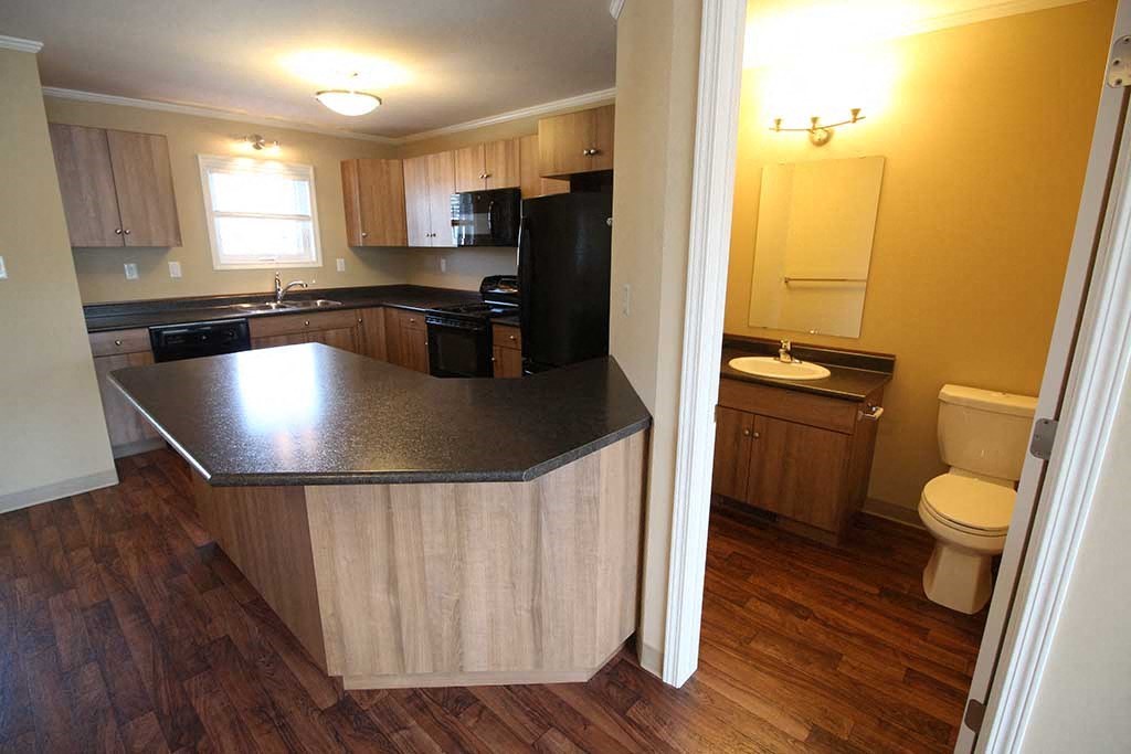 an empty kitchen with an island and a toilet