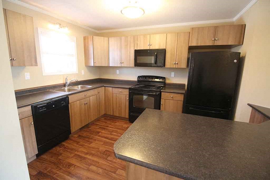 a kitchen with black appliances and wooden cabinets