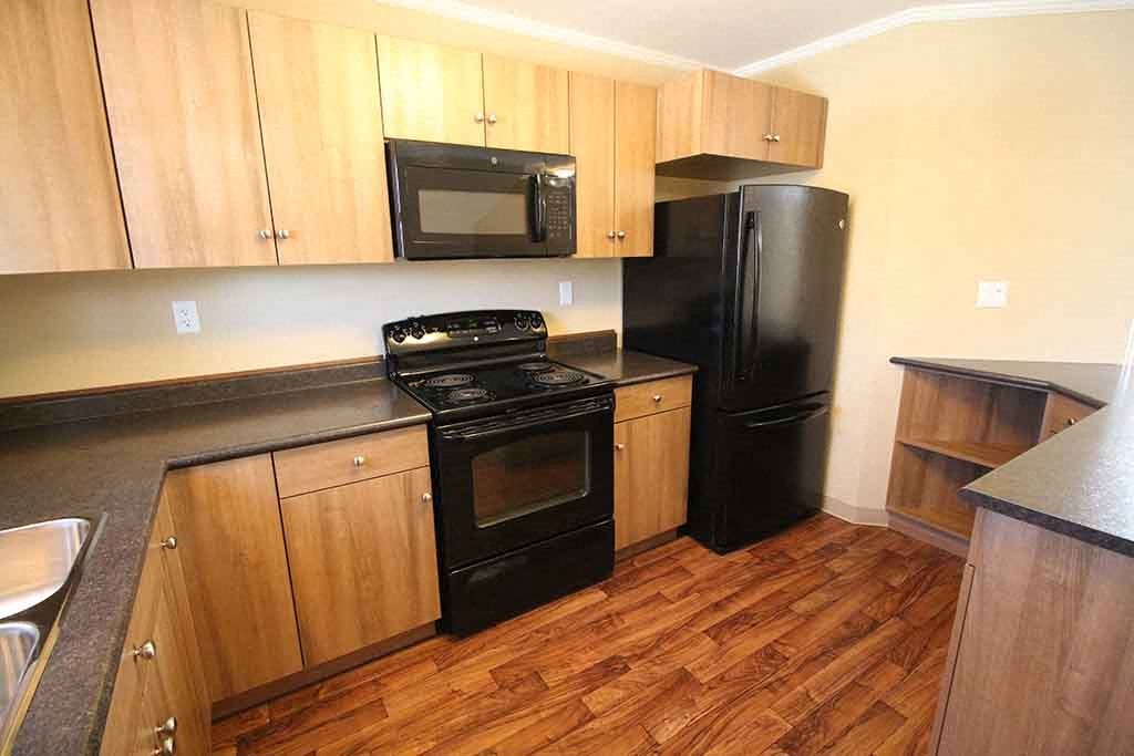 a kitchen with black appliances and wooden cabinets