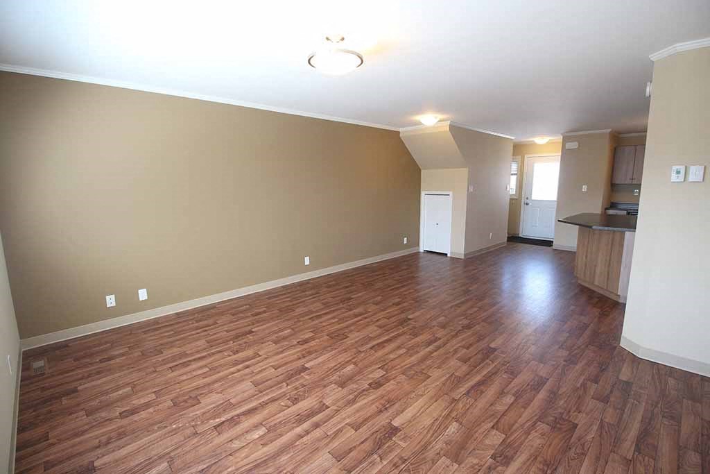 an empty living room with a hard wood floor