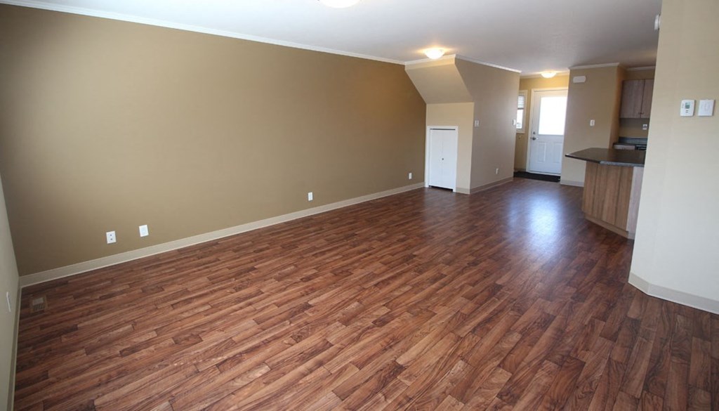 a empty living room with a wooden floor