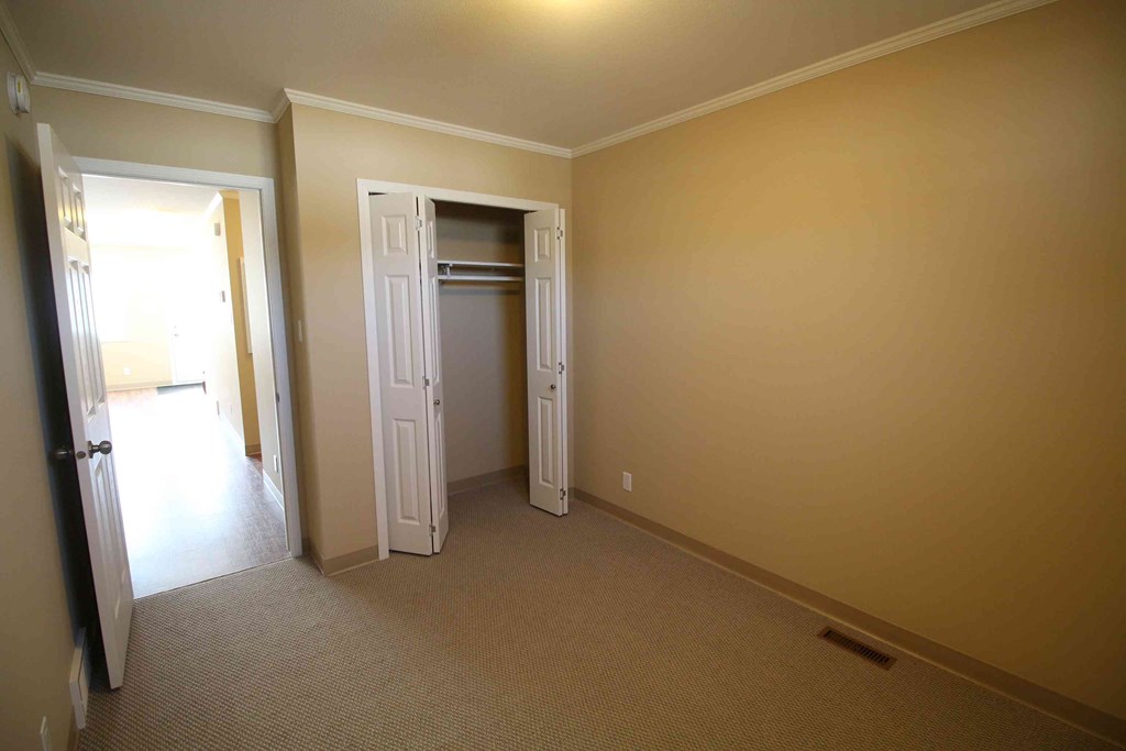 an empty room with two doors and a closet