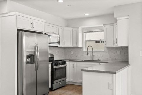 a kitchen with stainless steel appliances and white cabinets