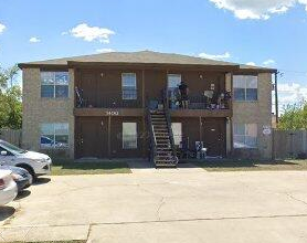 A two-story house with a car parked in front.