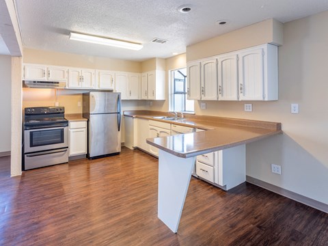 an empty kitchen with white cabinets and stainless steel appliances