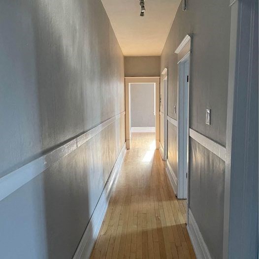 a hallway with a wood floor and silver walls