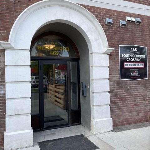 a brick building with a glass door and a sign