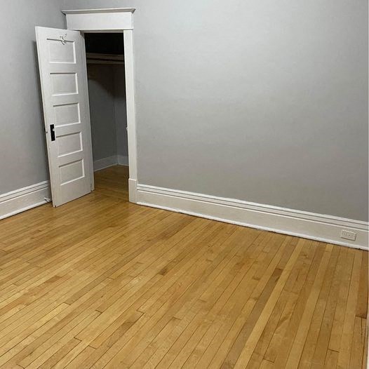 a room with a wooden floor and an open door