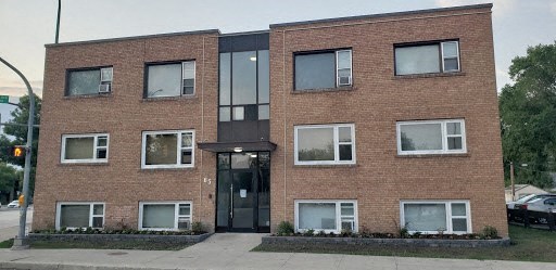 A red brick building with a black door and windows.