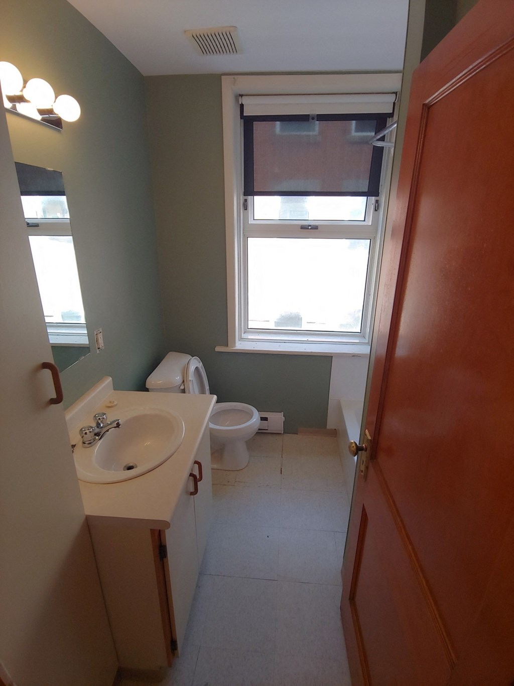a bathroom with a toilet and a sink and a window
