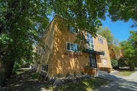 a yellow house with a tree in front of it