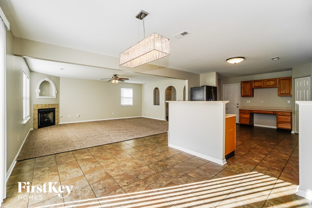 a kitchen and living room with a fireplace and a chandelier