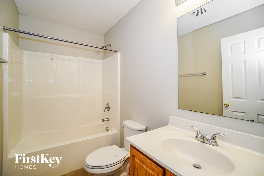 a bathroom with a sink toilet and shower and a mirror