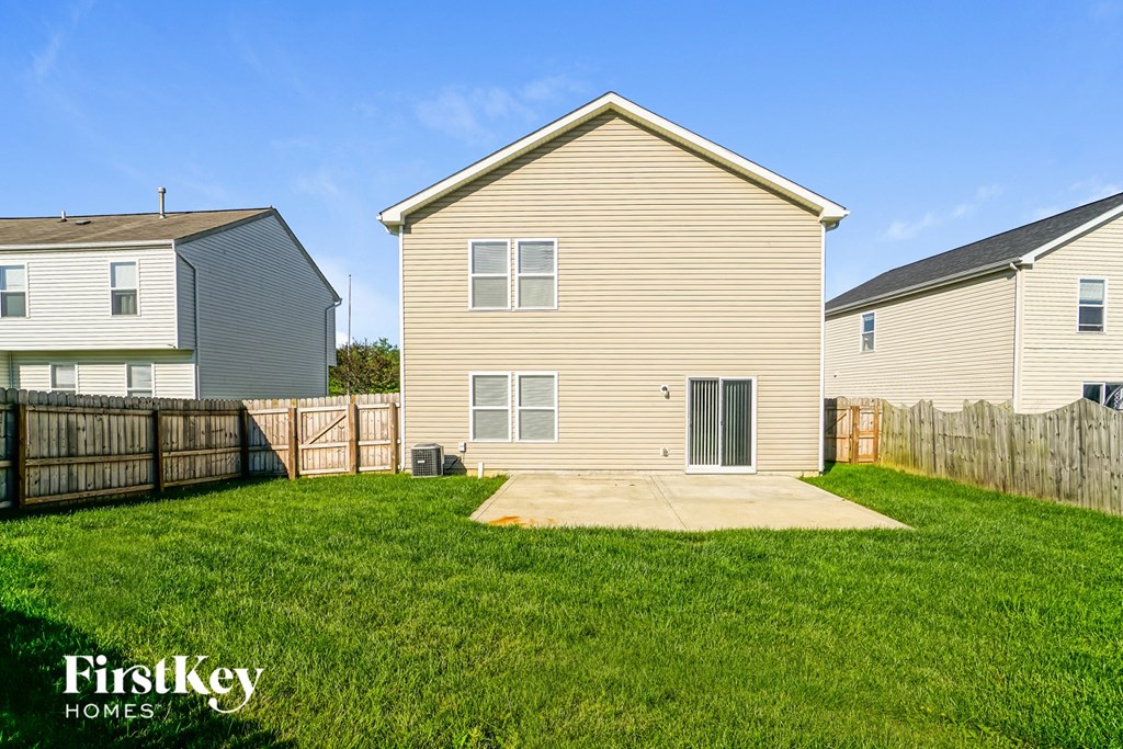 the backyard of a house with a yard and a fence