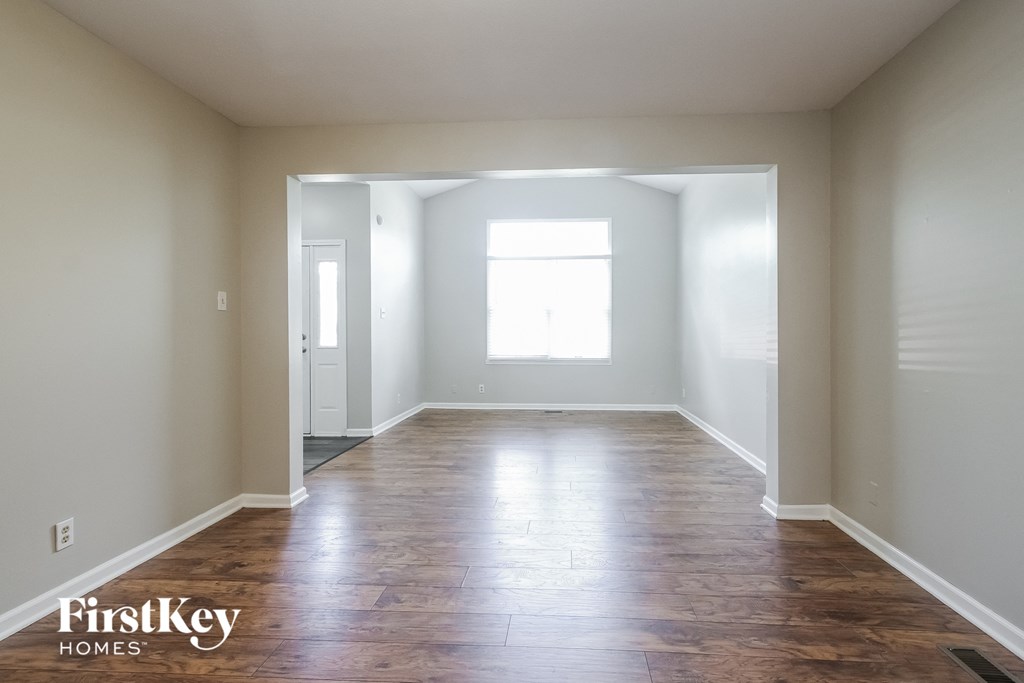 an empty room with wood floors and a window