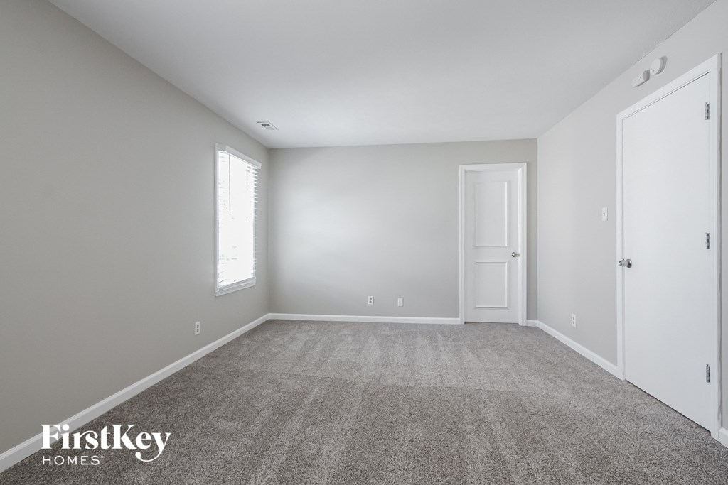 a bedroom with a carpeted floor and white walls