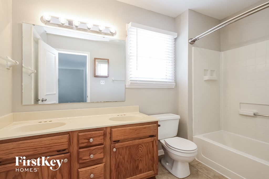 a bathroom with a sink toilet and a mirror and a tub