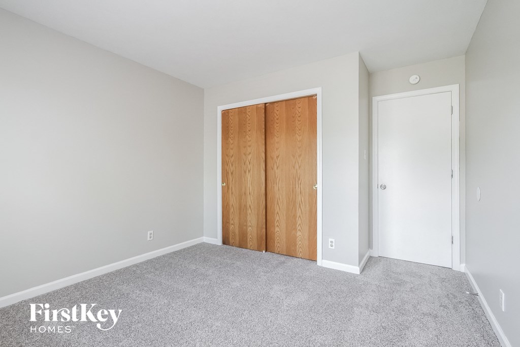 a bedroom with a closet and a door to a bathroom