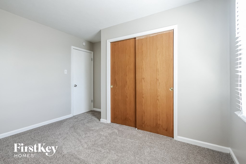 a bedroom with two closet doors and a carpeted floor
