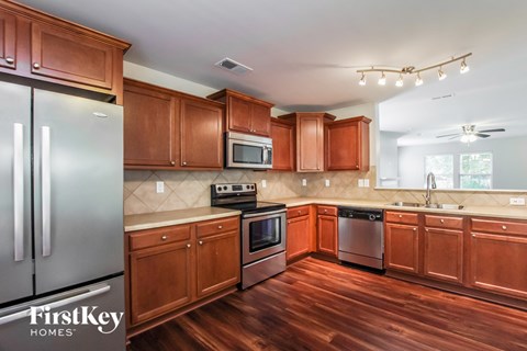 A kitchen with wooden cabinets and a refrigerator.