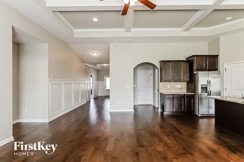 A spacious kitchen with dark wood floors and a ceiling fan.