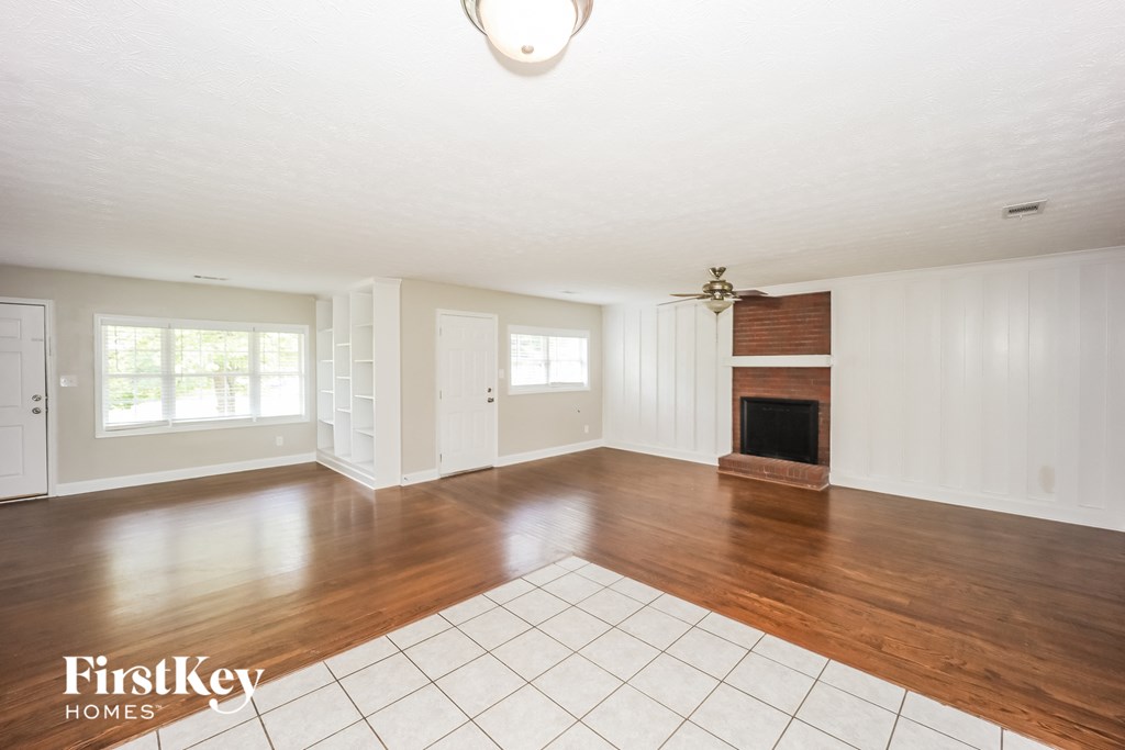 an empty living room with wood floors and a fireplace