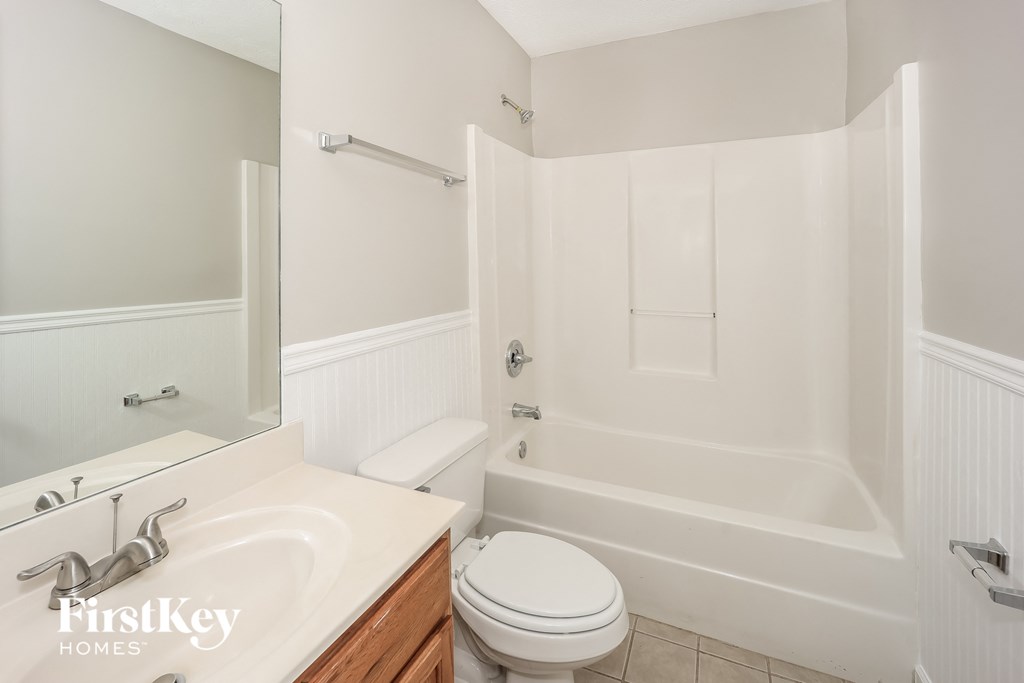 a white bathroom with a toilet and a tub and a sink