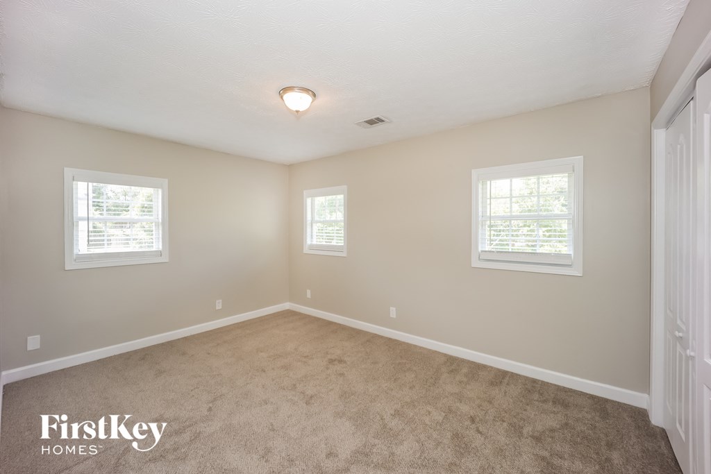 a bedroom with a carpeted floor and two windows