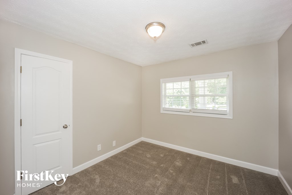 a bedroom with a white door and a window