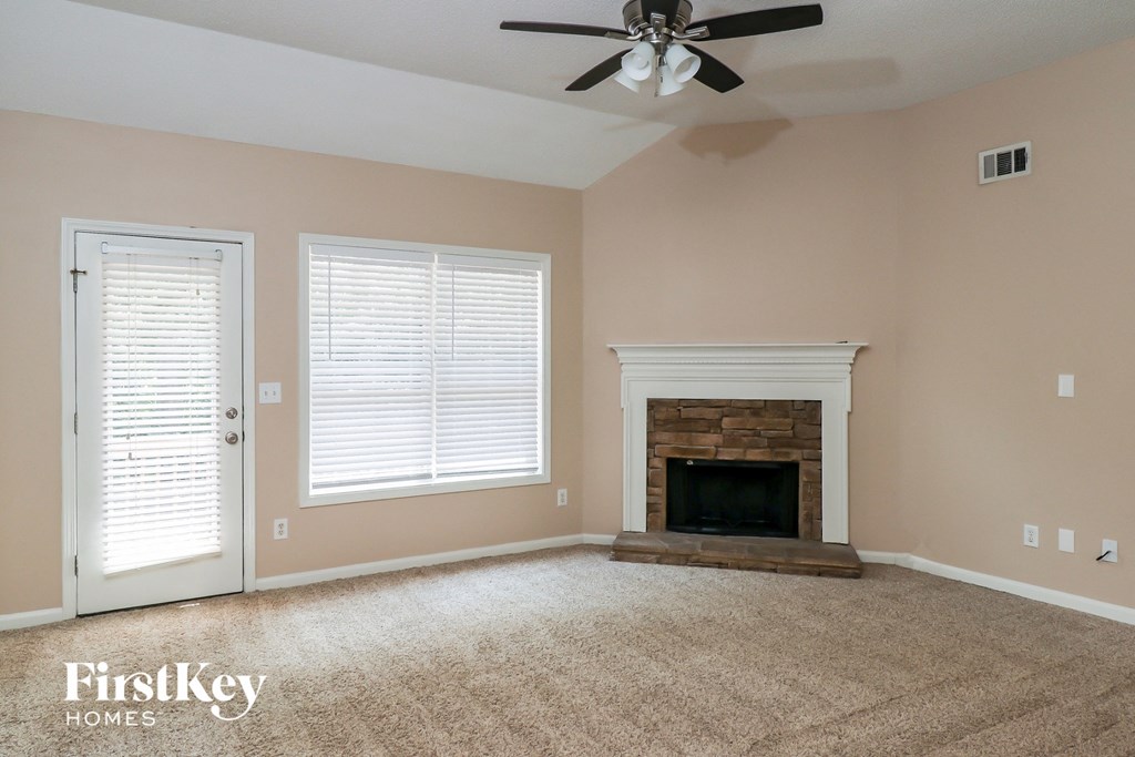 a living room with a fireplace and a ceiling fan