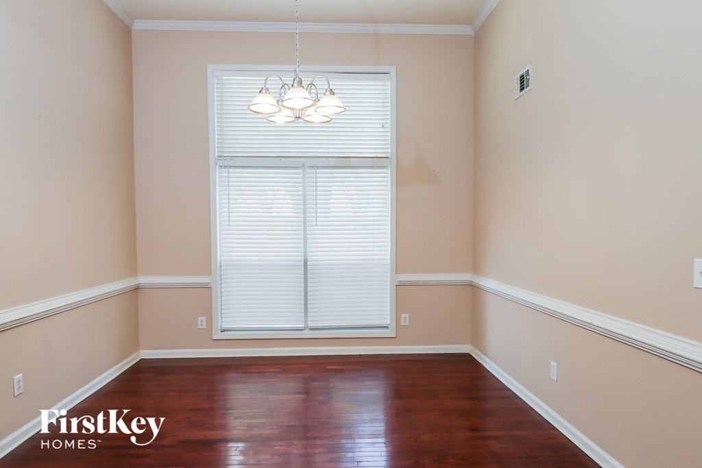 a dining room with wood floors and a large window