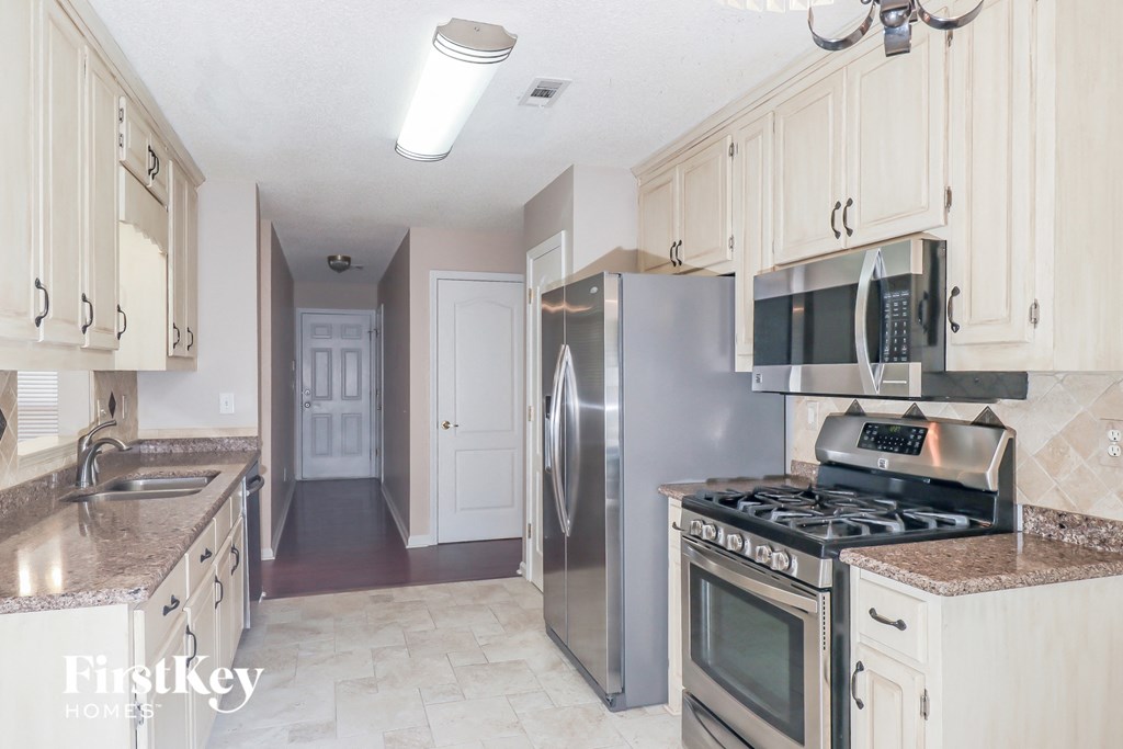 a kitchen with stainless steel appliances and white cabinets