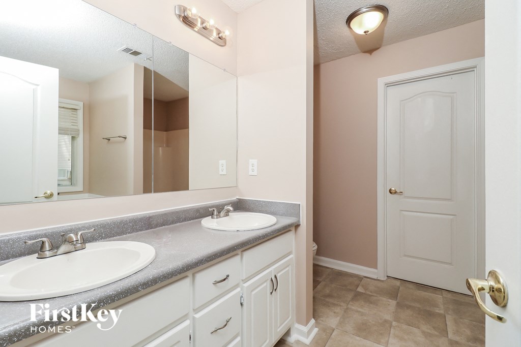a bathroom with two sinks and a large mirror