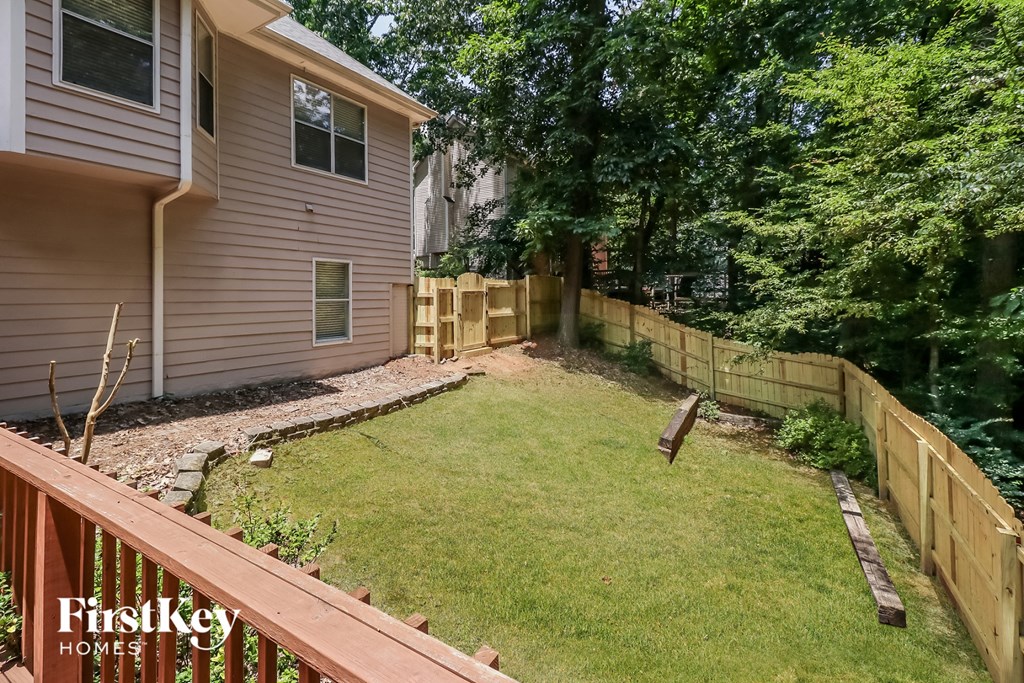 a backyard with a fence and a lawn and a house
