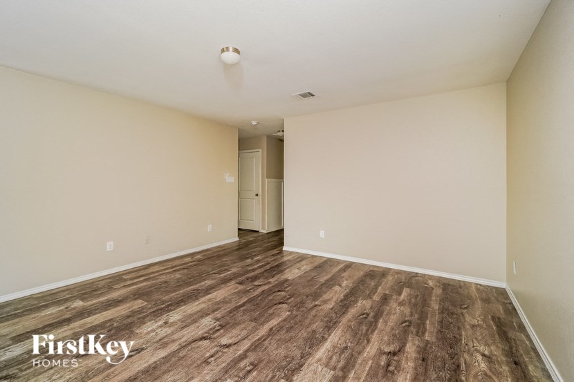 the living room and dining room are spacious with wood flooring and white walls