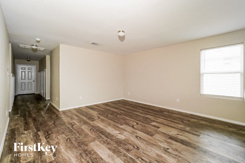 the living room and dining room of an empty house with wood flooring