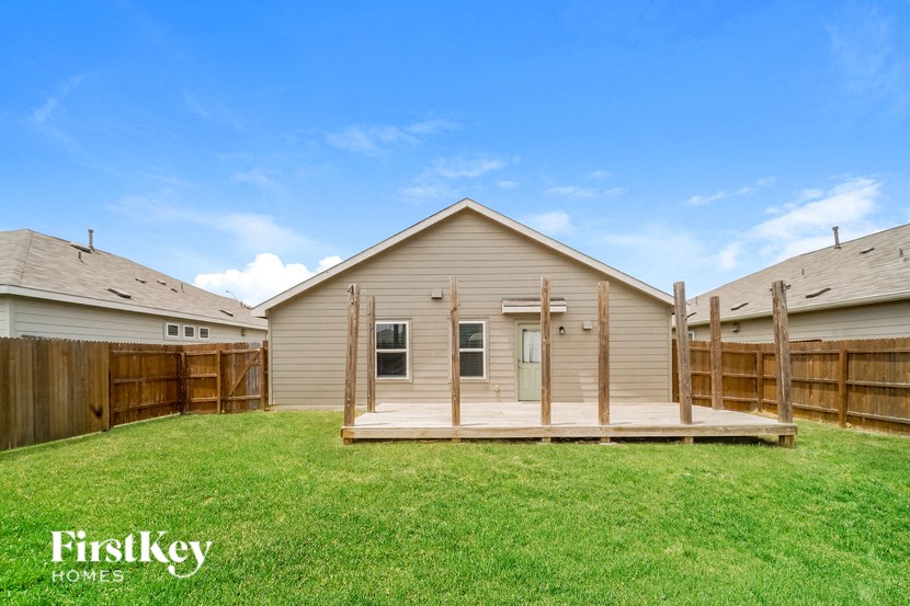 a backyard with a house and a green lawn