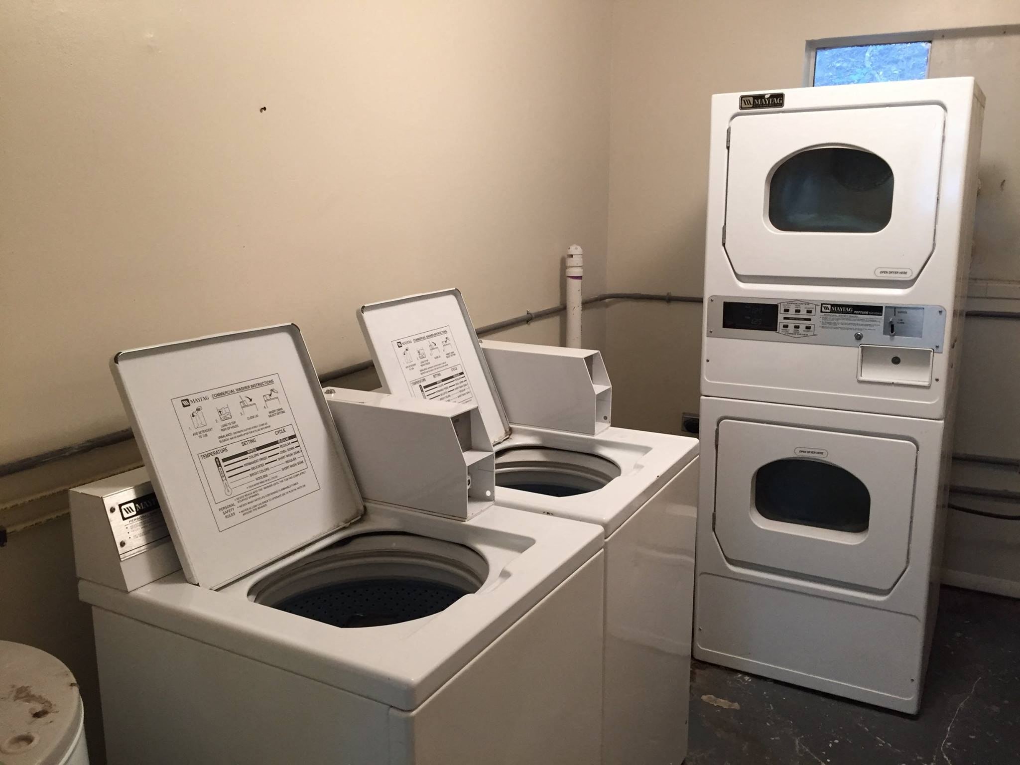 a group of washing machines and dryers in a room